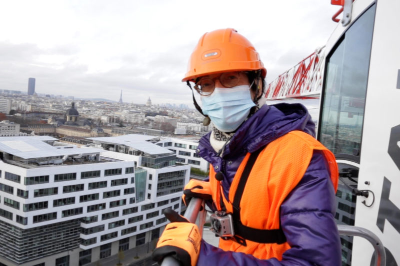 Anne monte sur une grue de chantier